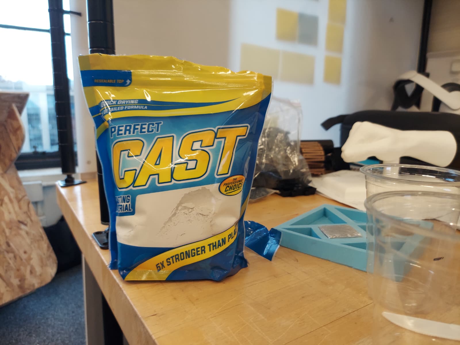 Perfect Cast plaster bag on desk next to silicone tangram mold